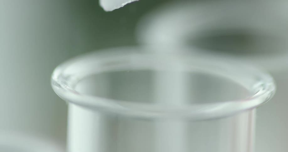 A granular powder is quickly poured into a narrow glass tube beneath it