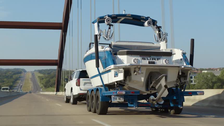 A vehicle towing a boat with a trailer