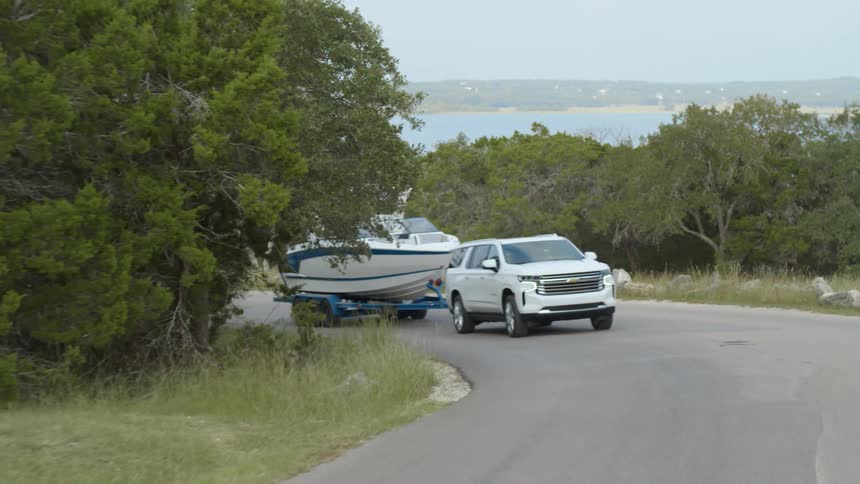 A vehicle is pulling a boat around the road