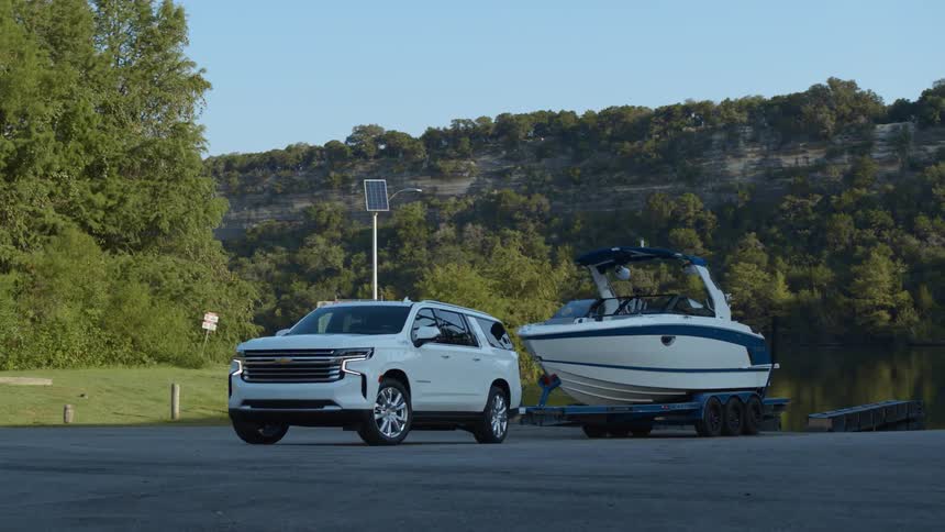 A vehicle backing up with a boat on the trailer