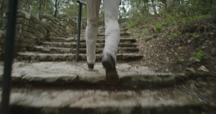 A person is jogging up a flight of stairs outdoors in spring