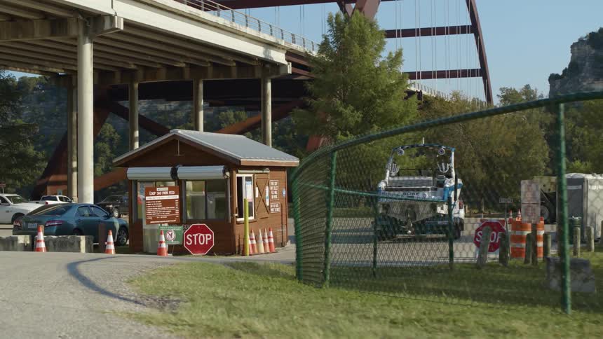 Car towing a boat parking under an arched bridge at morning