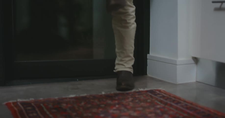A person removing their cowboy boots after walking through a door