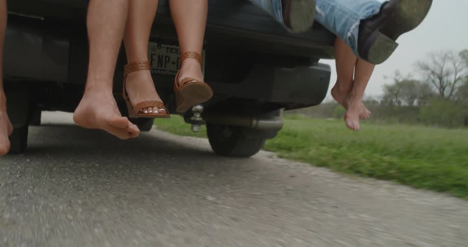 Man jumps on the back of a moving truck with his friends