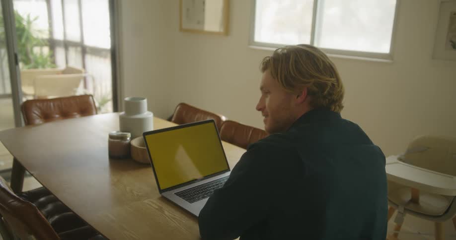 Man sitting at the desk in front of a laptop with a replaceable screen