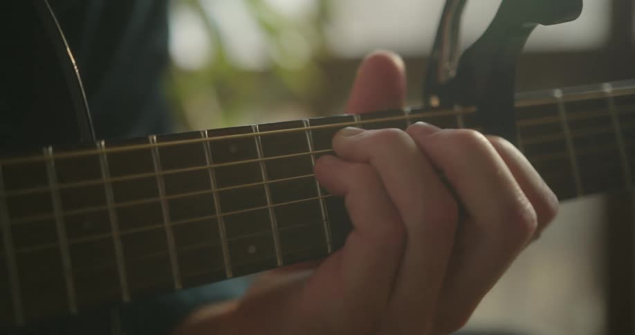 A person playing a guitar outside