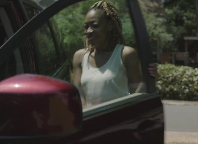 Happy woman hurriedly boarding a car parked next to her house