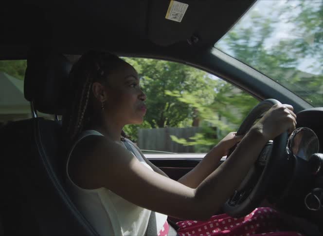 A woman driving a car down a road