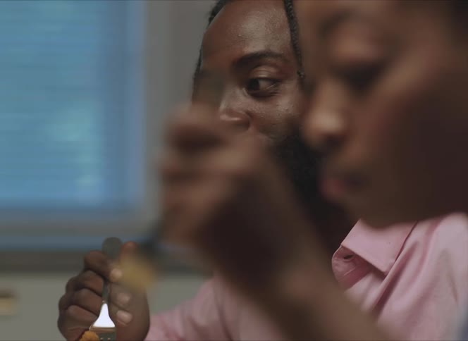 A man and woman eat together and the man is talking to someone across the table