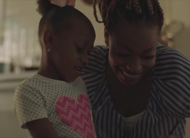 Happy mother helps her daugher with homework in the living room
