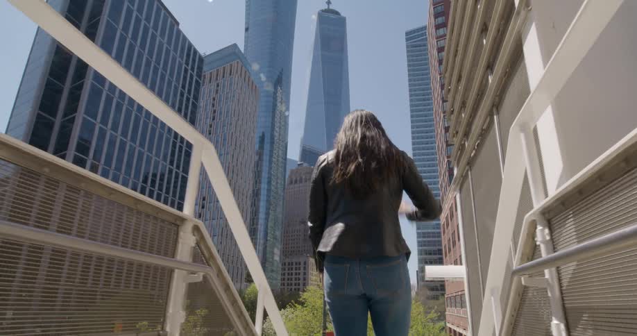 Woman walking out of a train station into the city downtown