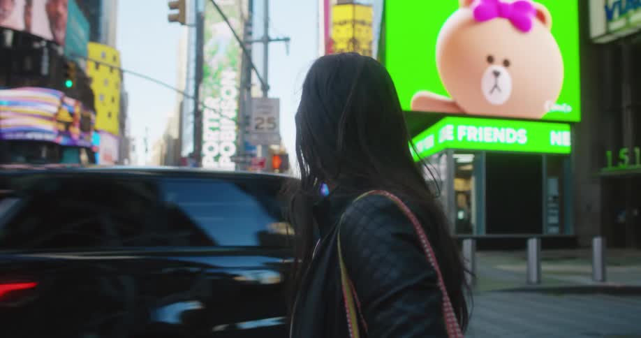 A woman standing on a sidewalk in a city