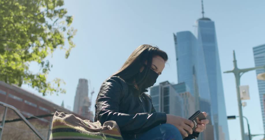 Woman sitting on a bench in the city using her smartphone