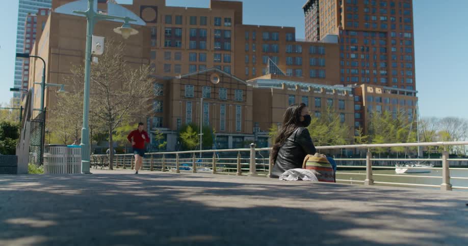 People jog and walk on a trail past a business complex downtown