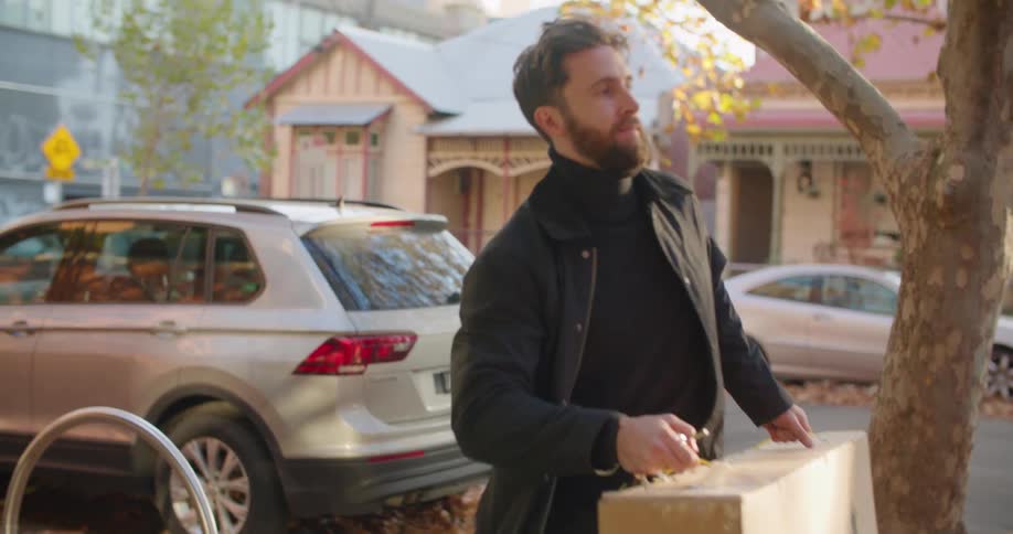 Man carrying a box from the car into the house at evening