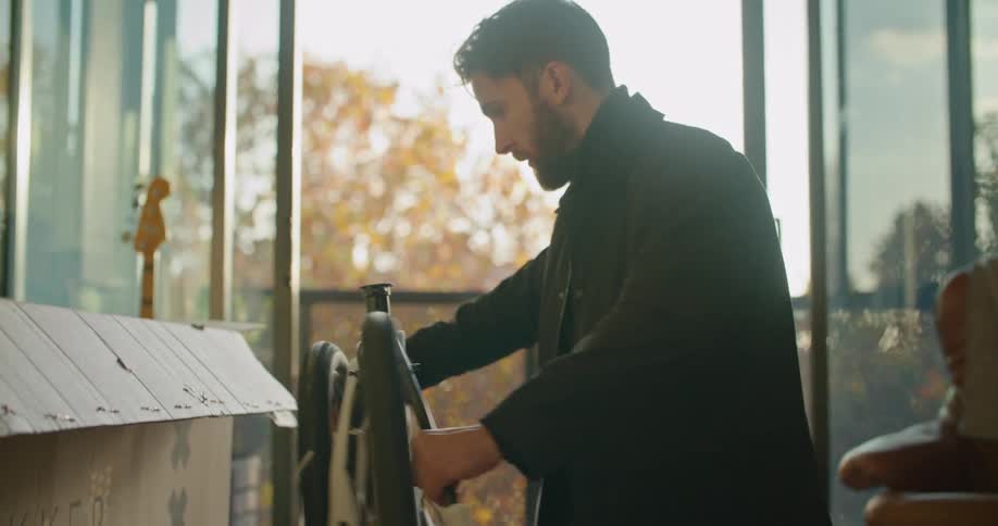 Man assembling a bycicle in the living room at home