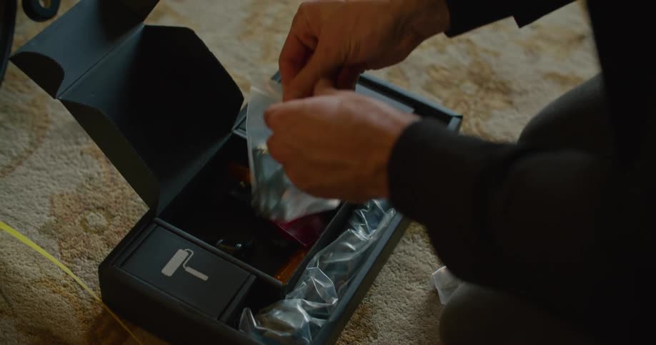 A person in a room with carpet taking tools from a toolbox