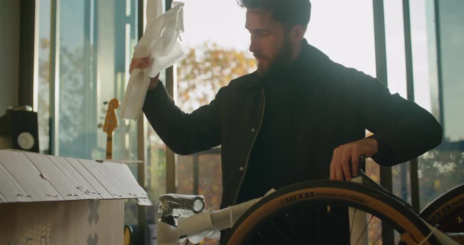 A man is putting together a bike indoors