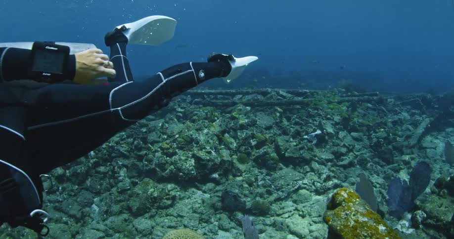 Female scuba diver swimming amongst some ruins