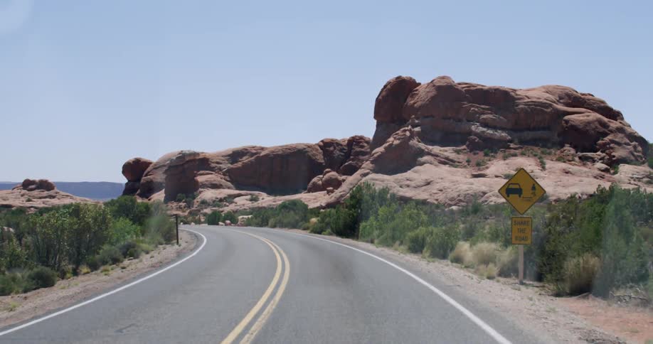 View moving down a winding road on a sunny day