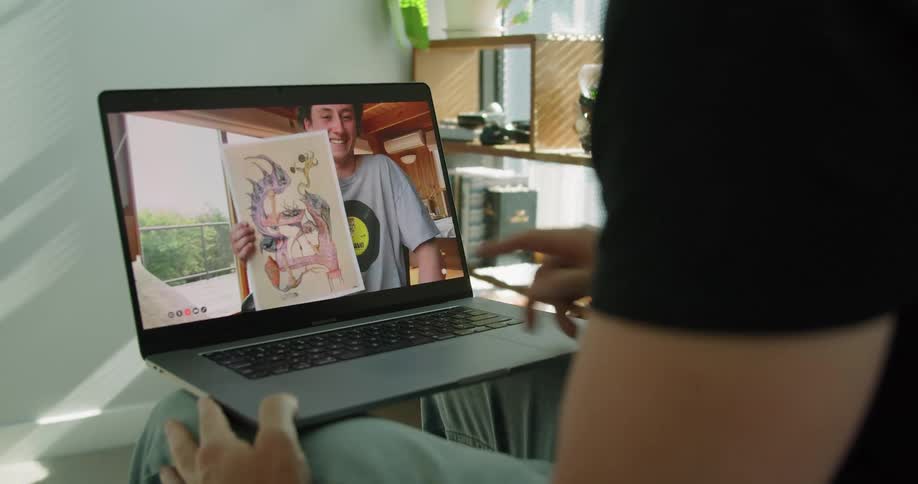 Two friends having a video call on a laptop at home