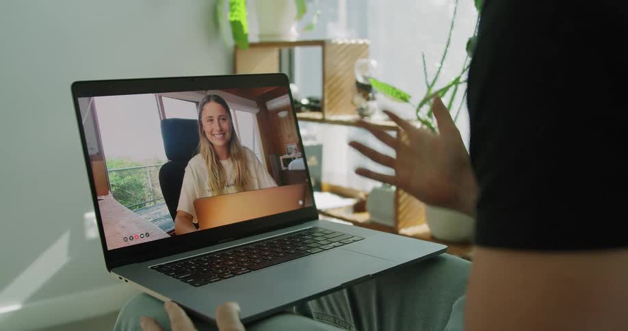 Two young people having a video call on a laptop at home