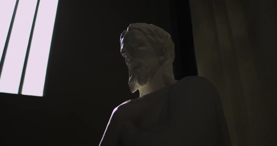 A statue near a window with bars and the sun is shining through