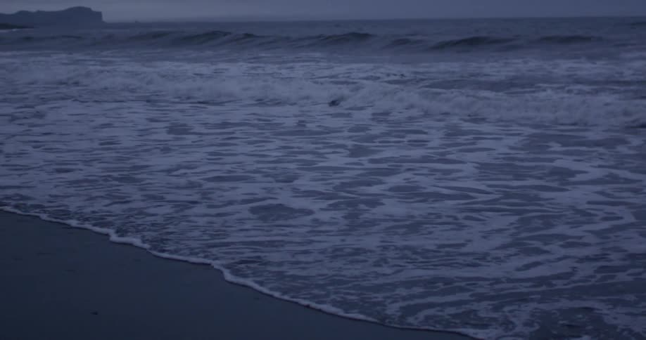 Waves slowly coming ashore on a sandy beach