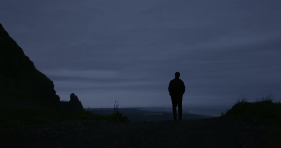 A man walks down a path at dusk