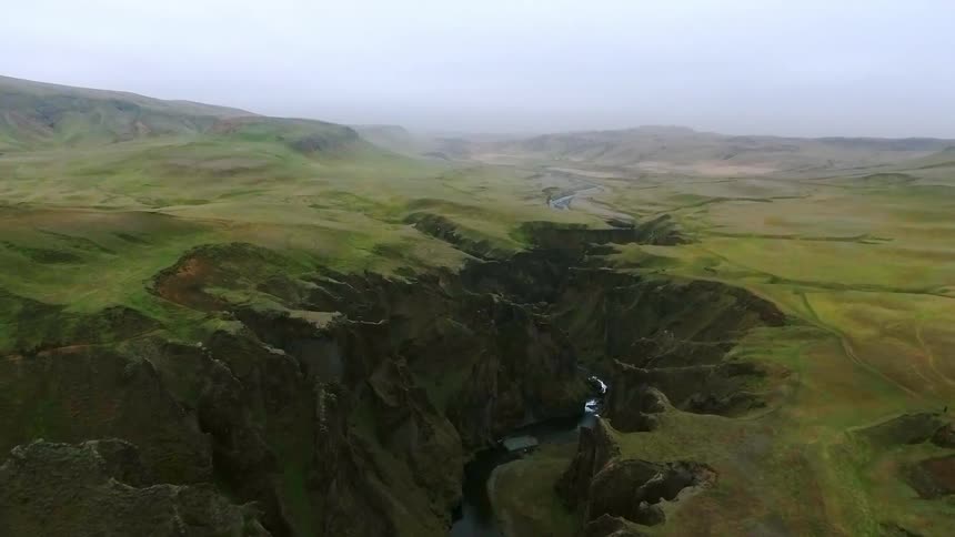 Aerial view of a river in a deep green canyon
