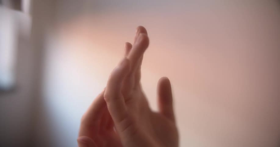 Hands in a room touching with a wall in the background