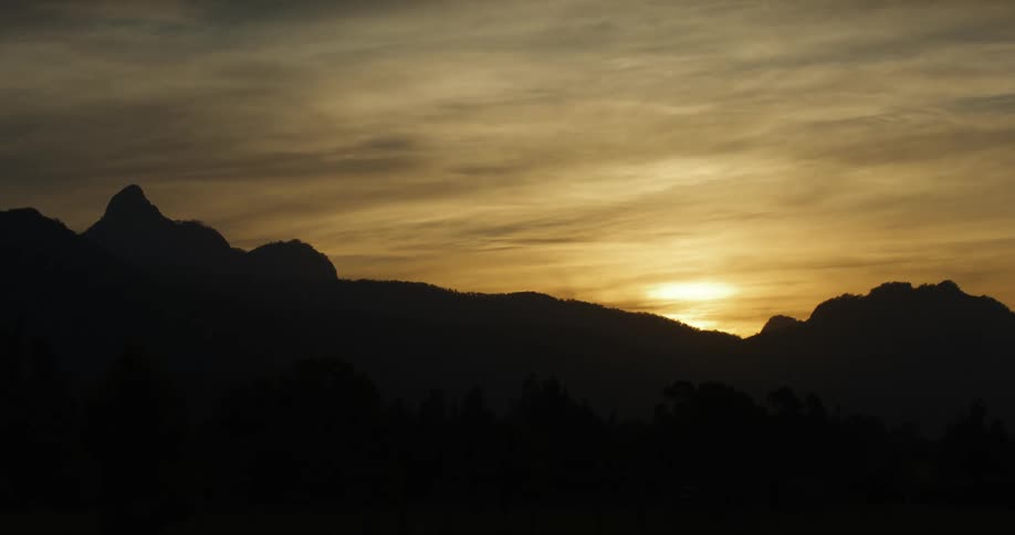 Sun setting over the silhouette of the mountains