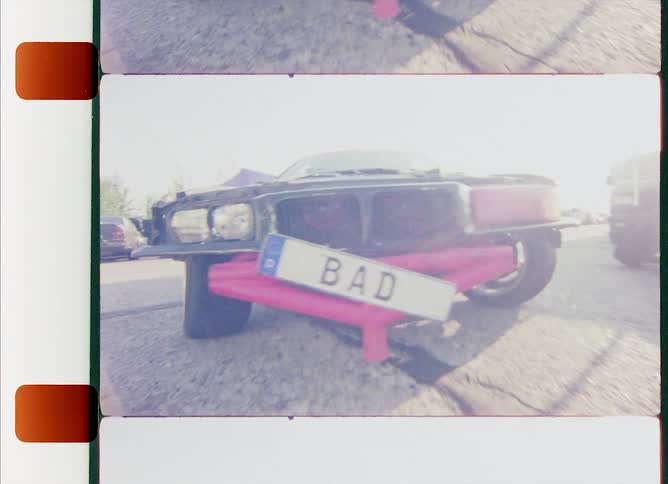 Close up of a totalled car driving on reverse caught on vintage film