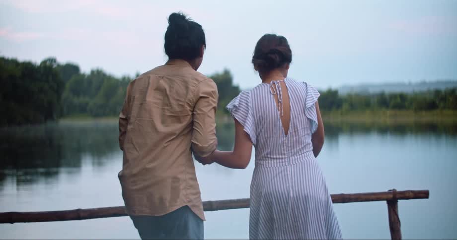 Man and Woman running towards the lake and pointing