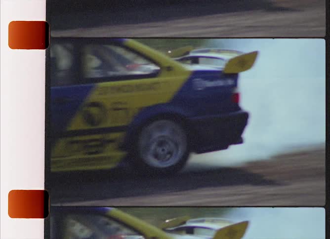 A sports car skids and swerves along an outdoor raceway while its tires emit smoke