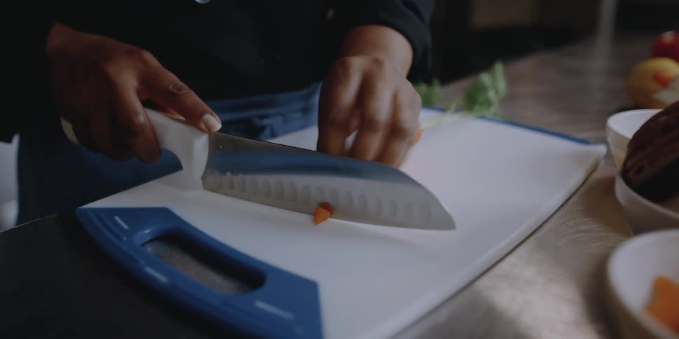 A woman cutting food on a cutting board