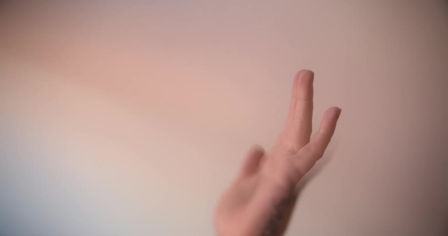 A woman waving her hand in the air inside a room