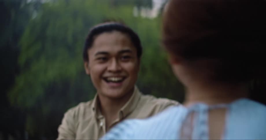 A man and woman laugh and dance on the shore