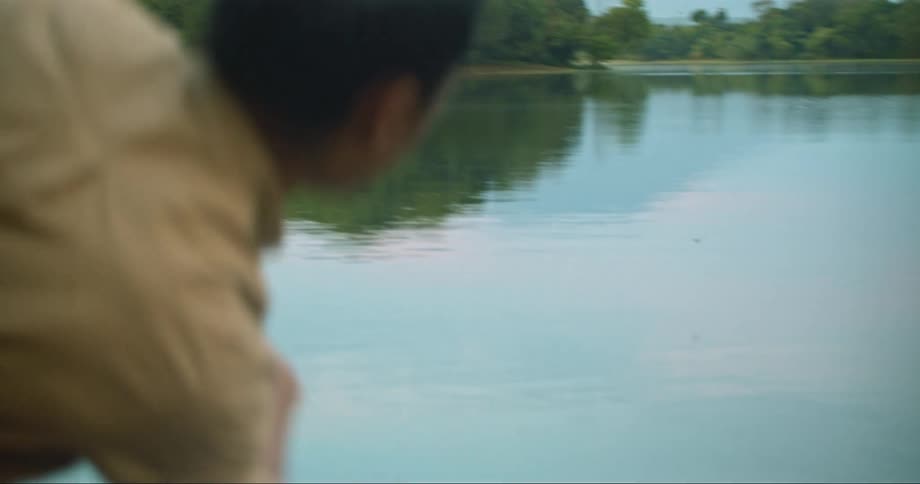 A man skips a stone across a lake during the day