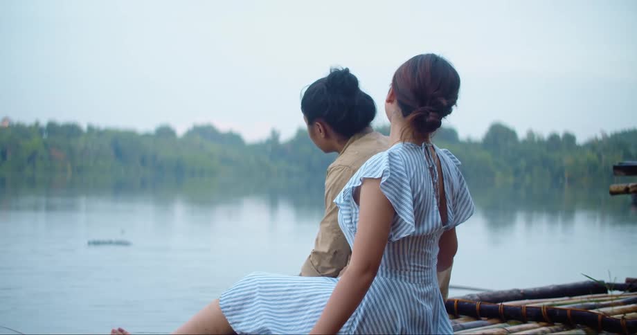 Man and Woman sitting next to some water