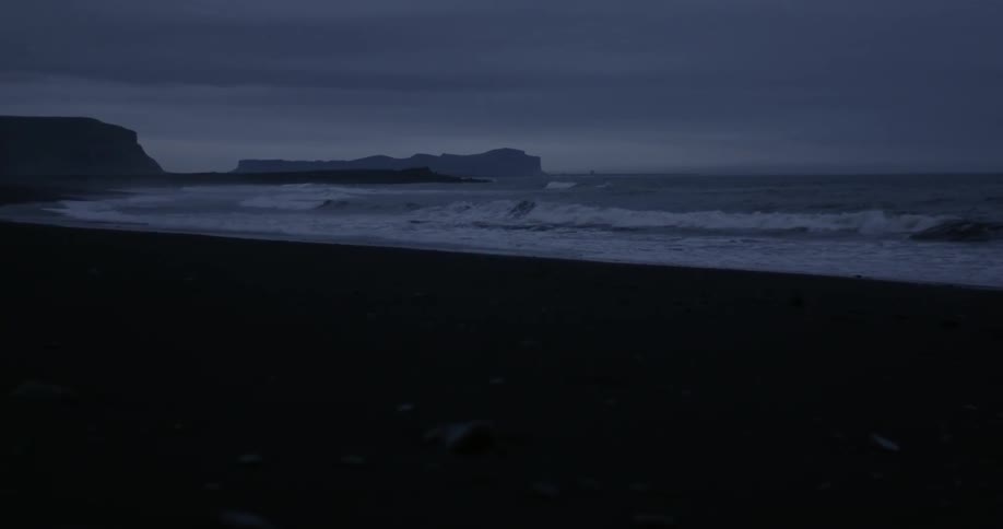 Ocean waves splashing to shore at sunset