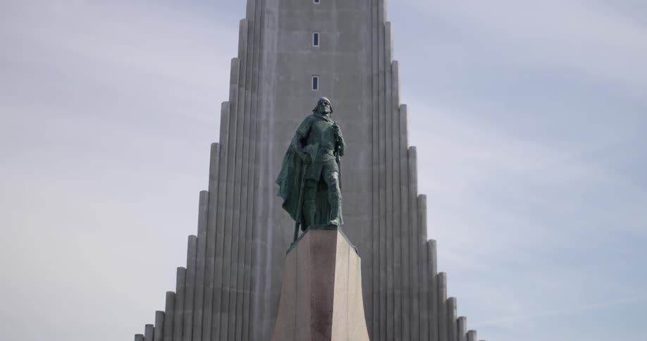 A statue sits in front of a tall building