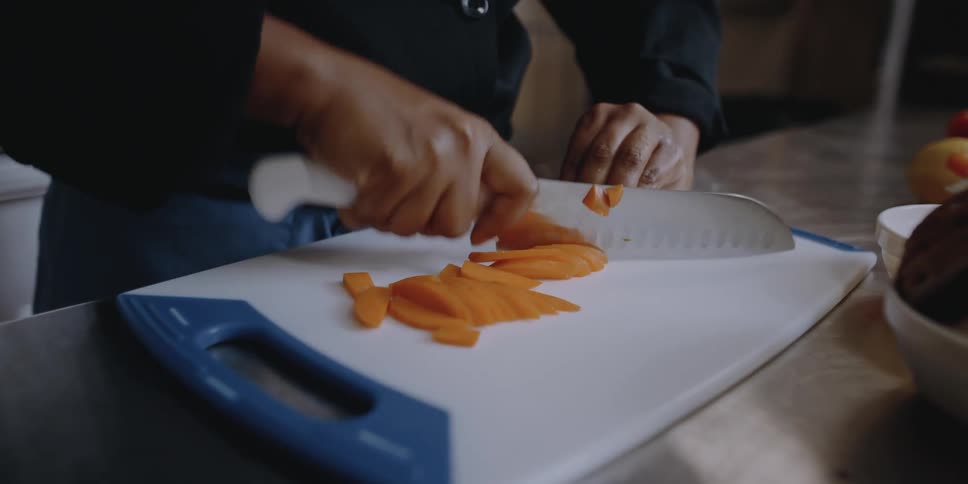 A woman cutting food on a cutting board