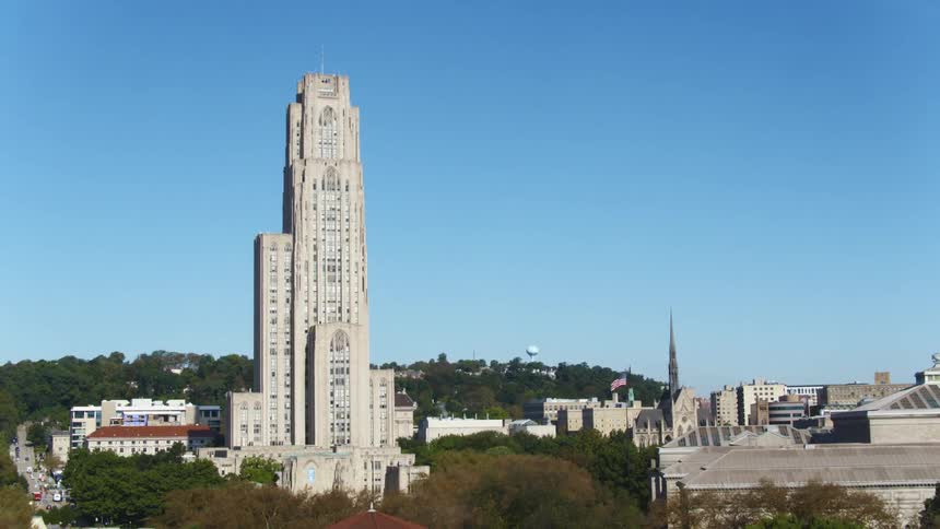 A tall building looms over the surrounding buildings in a city during the day