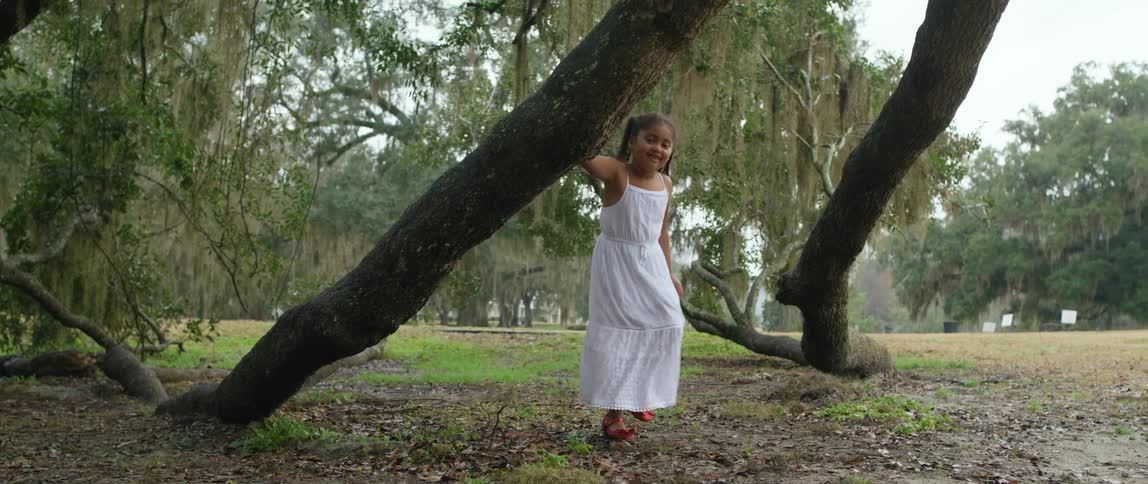 A girl is running around in a park