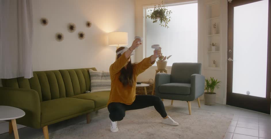A woman is crouching and moving around using virtual reality