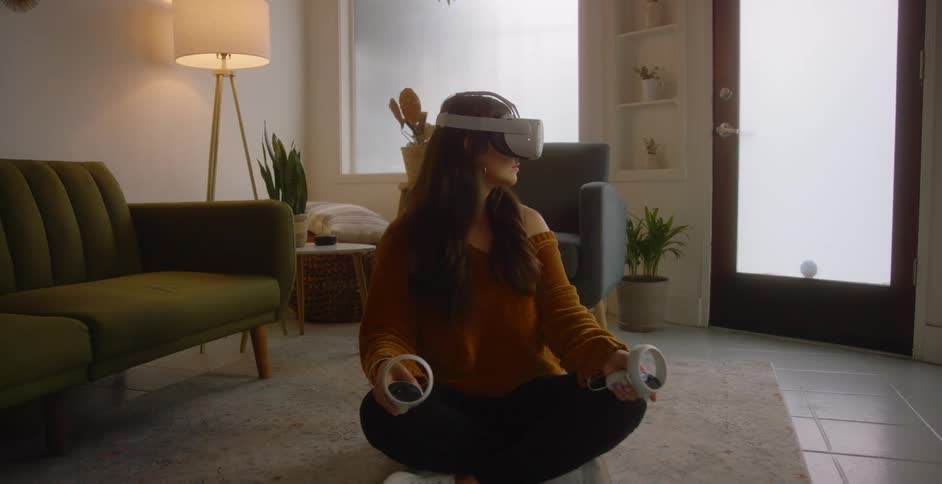A girl is sitting in her living room and playing a virtual reality game