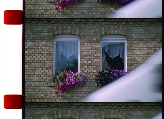 A view of a building with a car driving by the front of it