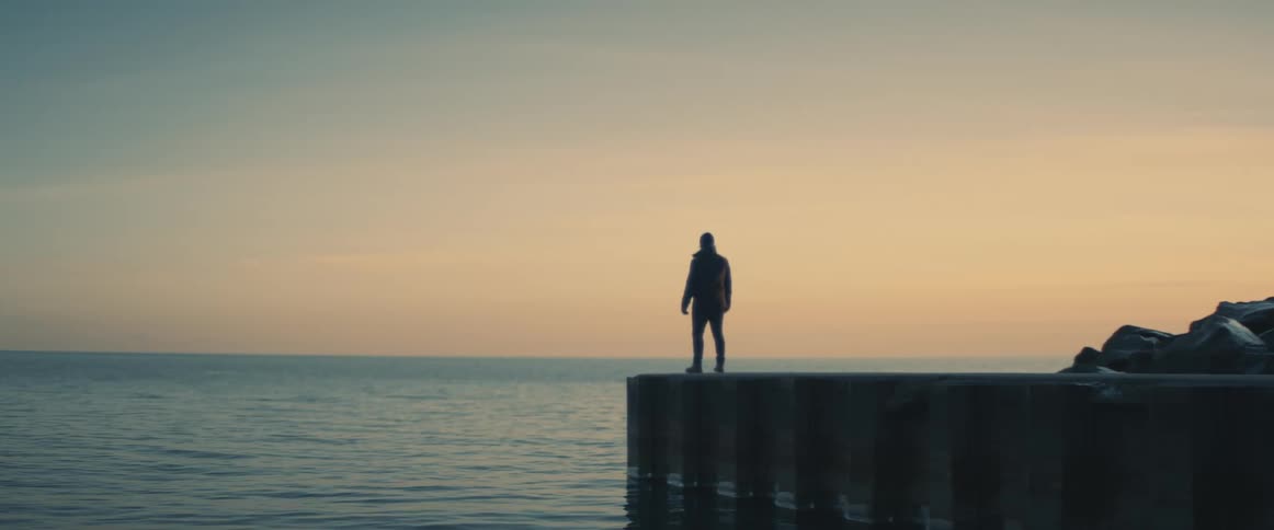 A man standing at the edge of a waterway