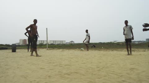 Group of young men playing soccer over the sand